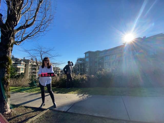 Two real estate agents standing in front of a sold condo in Coquitlam